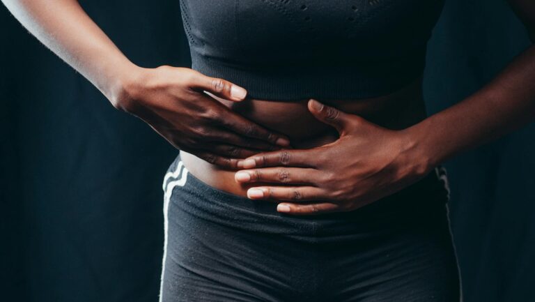 Person holding stomach in discomfort