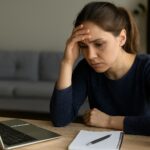 A woman working on her laptop feeling anxious