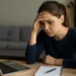 A woman working on her laptop feeling anxious
