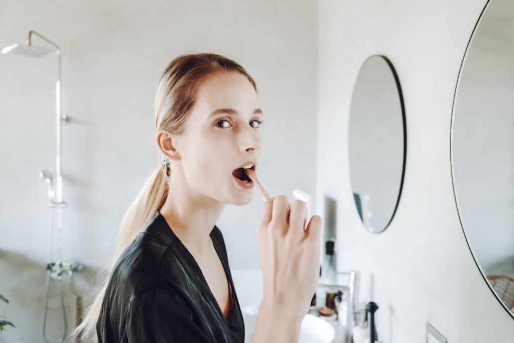a woman washing her face with the leftover toothbrush water
